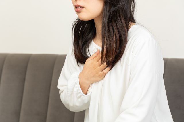 胸部の痛みを感じる女性
