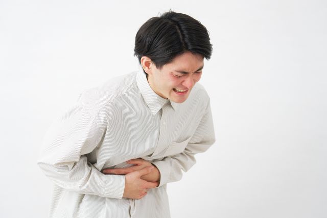 腹痛で痛がる男性