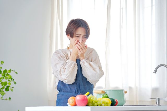 キッチンで吐き気がする女性