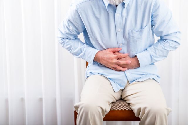 腹部をおさえる男性