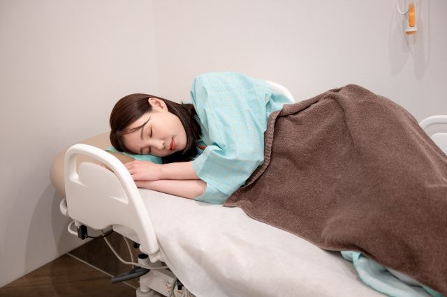 検査後に眠る女性